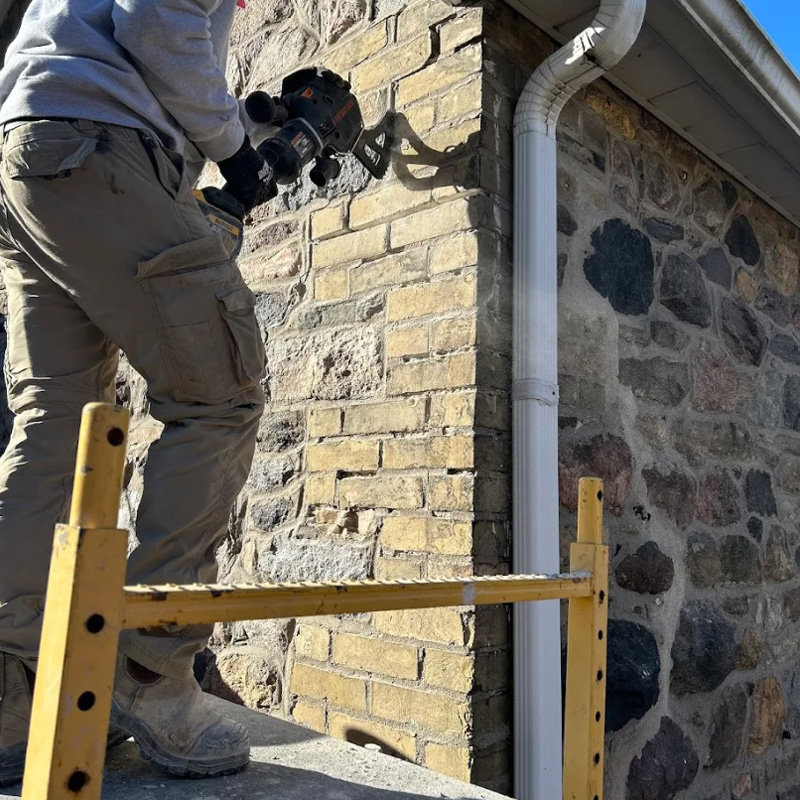 man repairing stone on a home